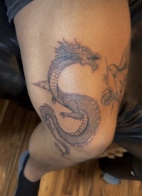 a tattoo of a dragon on a man's knee